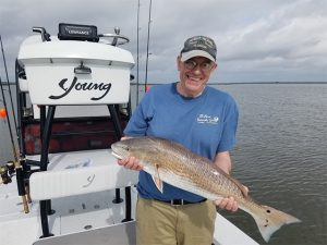 Proud Fisherman Amelia Island Fishing, holds a 22-inch Redfish caught in the backwaters.